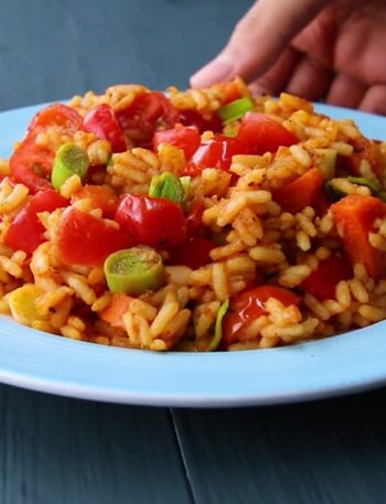 A plate of healthy veggie fried rice with carrots, bell peppers, and cilantro